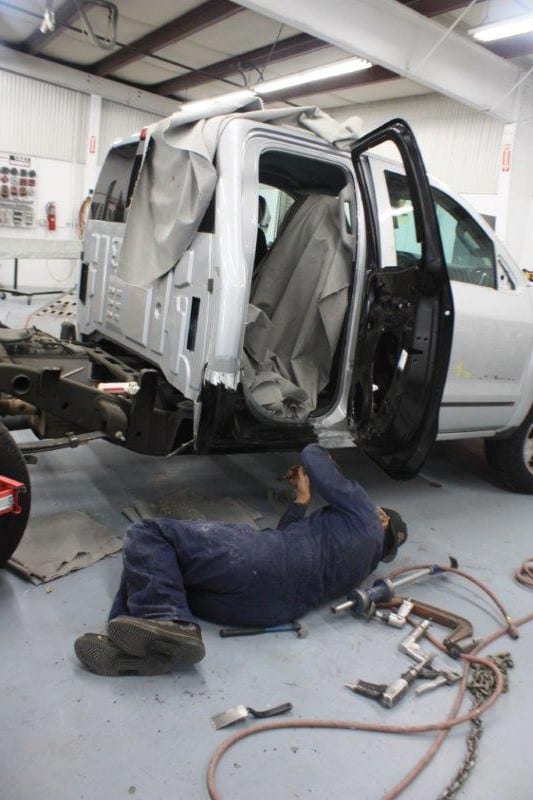 Mechanic at Trew Auto Body doing auto body repair on a truck 